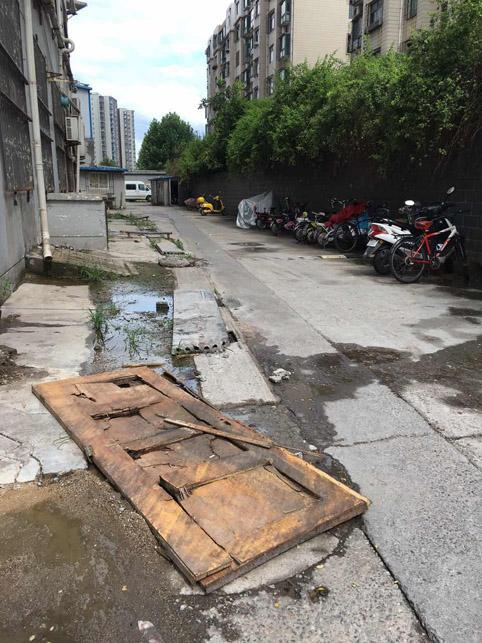 济南夏日花园酒店外的污水井盖松动，上面只铺了一块木板，最后物业“让步”安装了新井盖