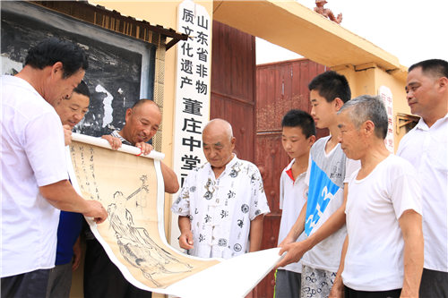董友环（左四）和董兆生（右二）在董庄中堂画传习所前跟庄乡欣赏先辈画作《老君骑牛出函关》  摄影  刘明明