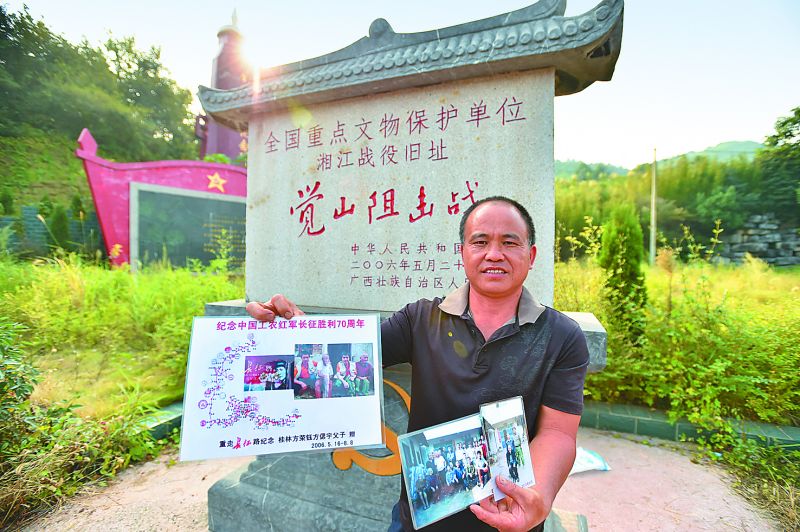 全州县才湾镇觉山铺村的唐春林在展示父亲唐功文救助红军战士杨成武的故事图片。