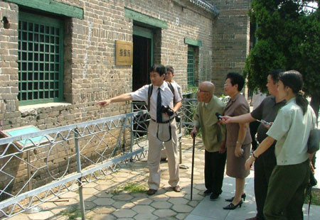 2005年 ,仵德厚老人在清真寺观看弹痕累累的墙壁