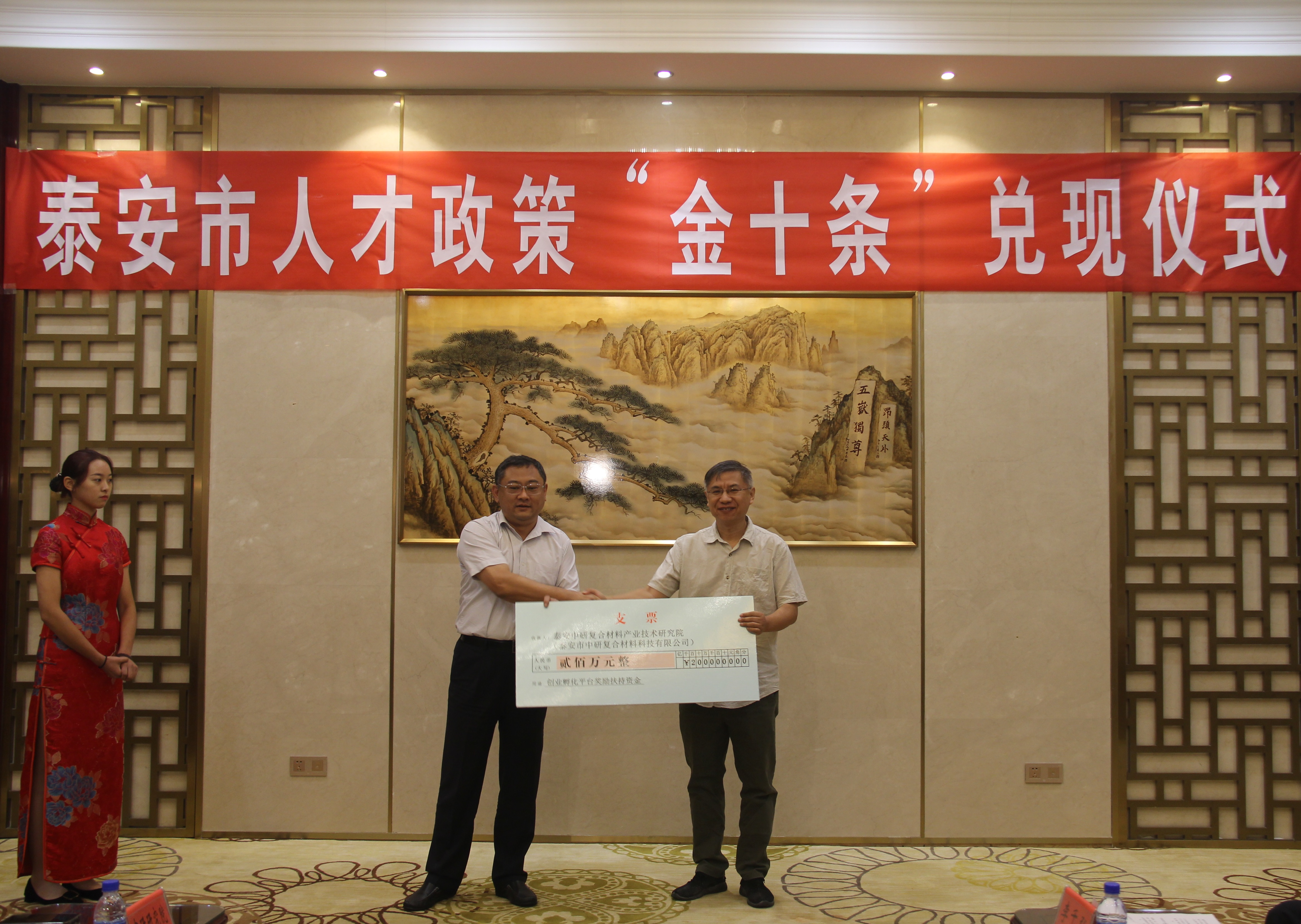 兑现人才政策“金十条”首批奖励扶持资金，泰安市委组织部部长、市人才工作领导小组组长高尚山(左)为泰安中研复合材料产业技术研究院发放创业孵化平台奖励扶持资金