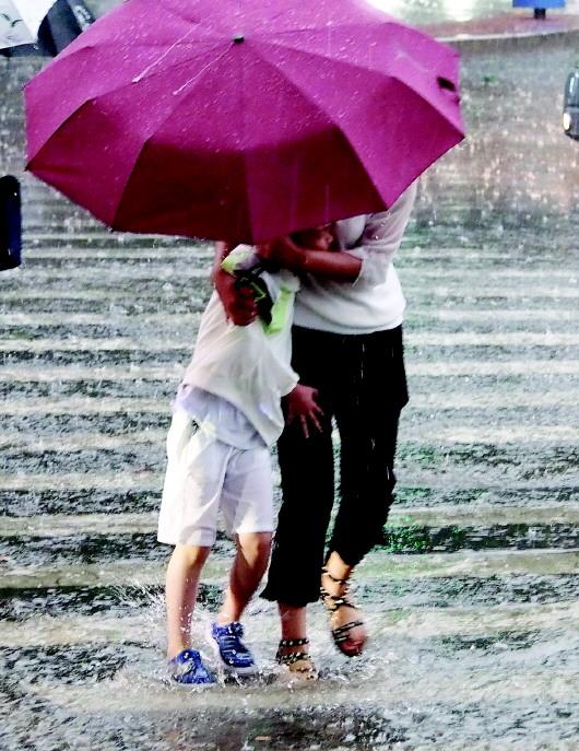 7月6日，省城济南出现强降雨过程，行人在急雨中涉水前行。□大众报业记者 周青先 报道