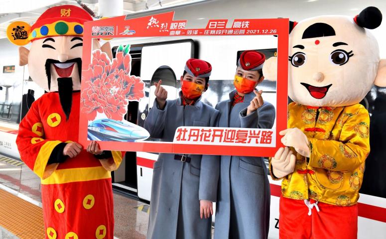 12月26日，在菏泽东站，工作人员在列车前合影。