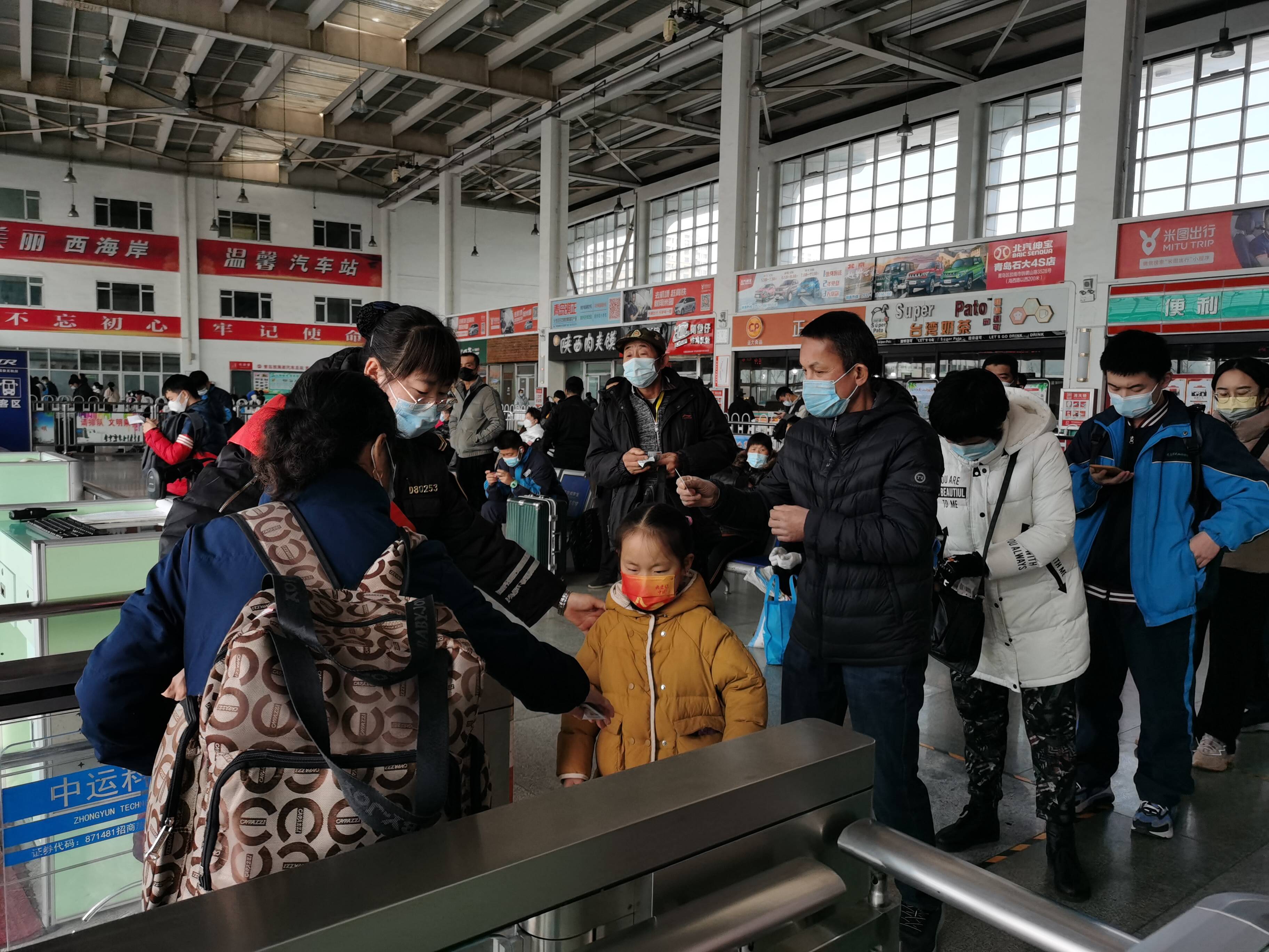 西海岸汽车总站内，候车乘客有序进站。