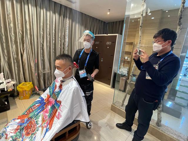 屈卫东（中）在为顾客理发