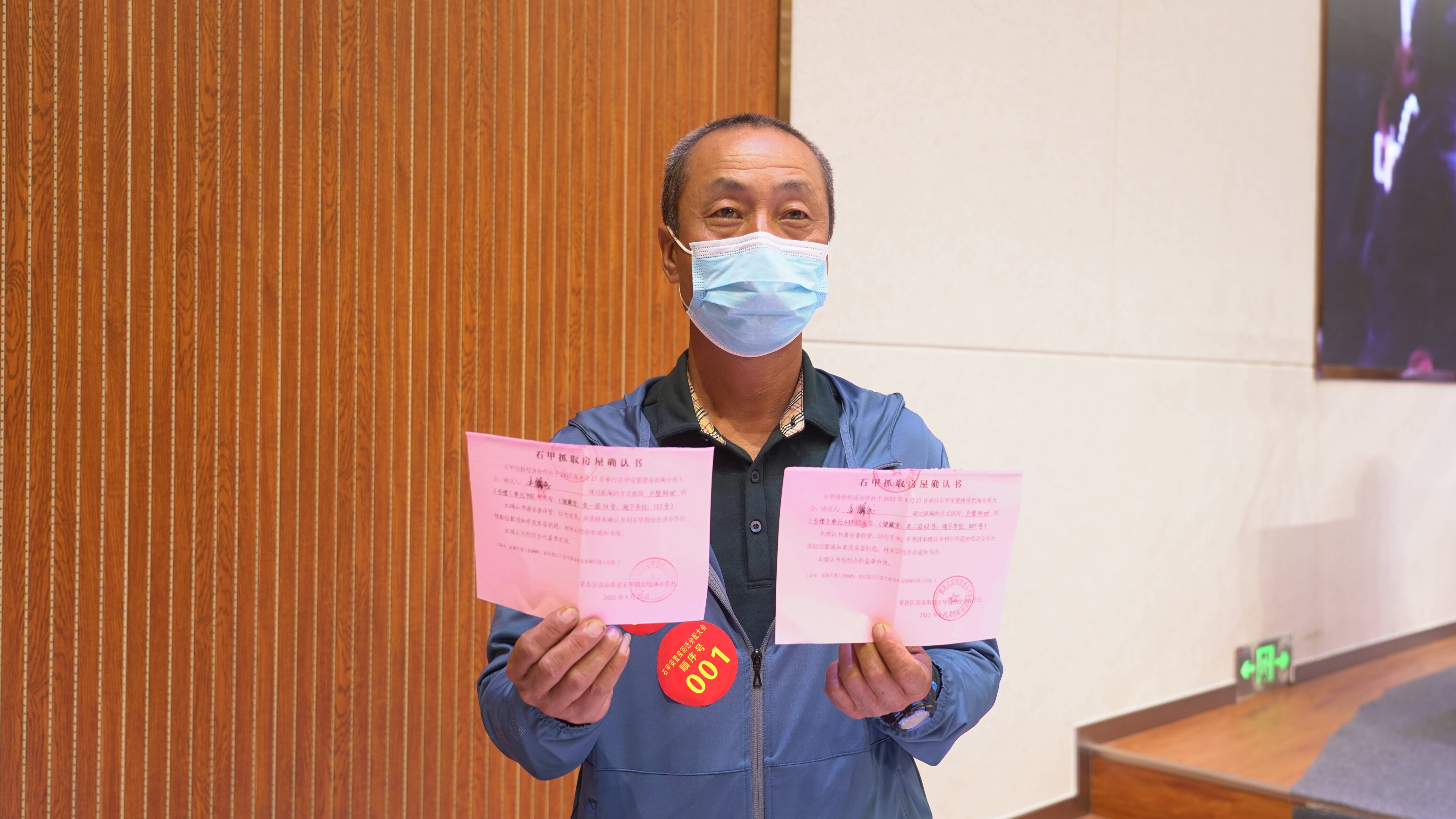 逄锦成抓到满意的房子后向记者展示抓取房屋确认书。