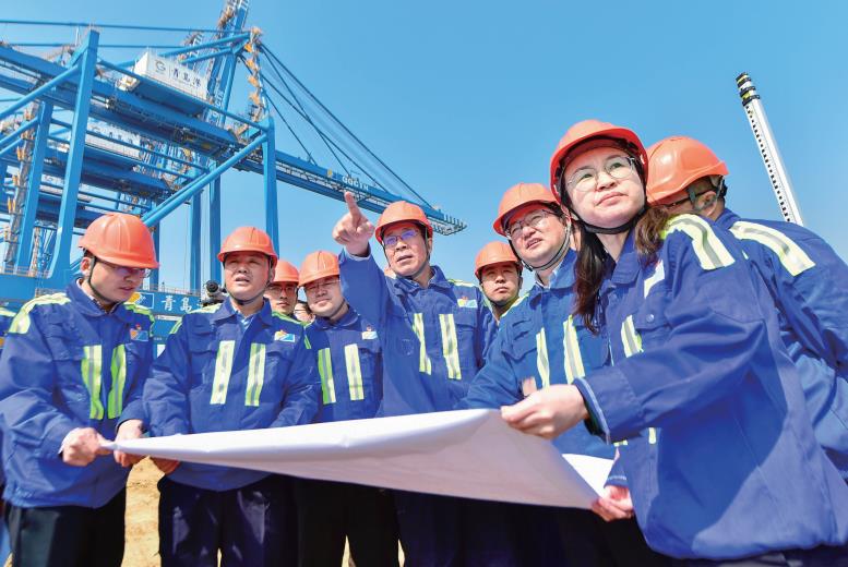 张连钢（中）与“连钢创新团队”成员在码头上研究建设方案。（本报资料照片）