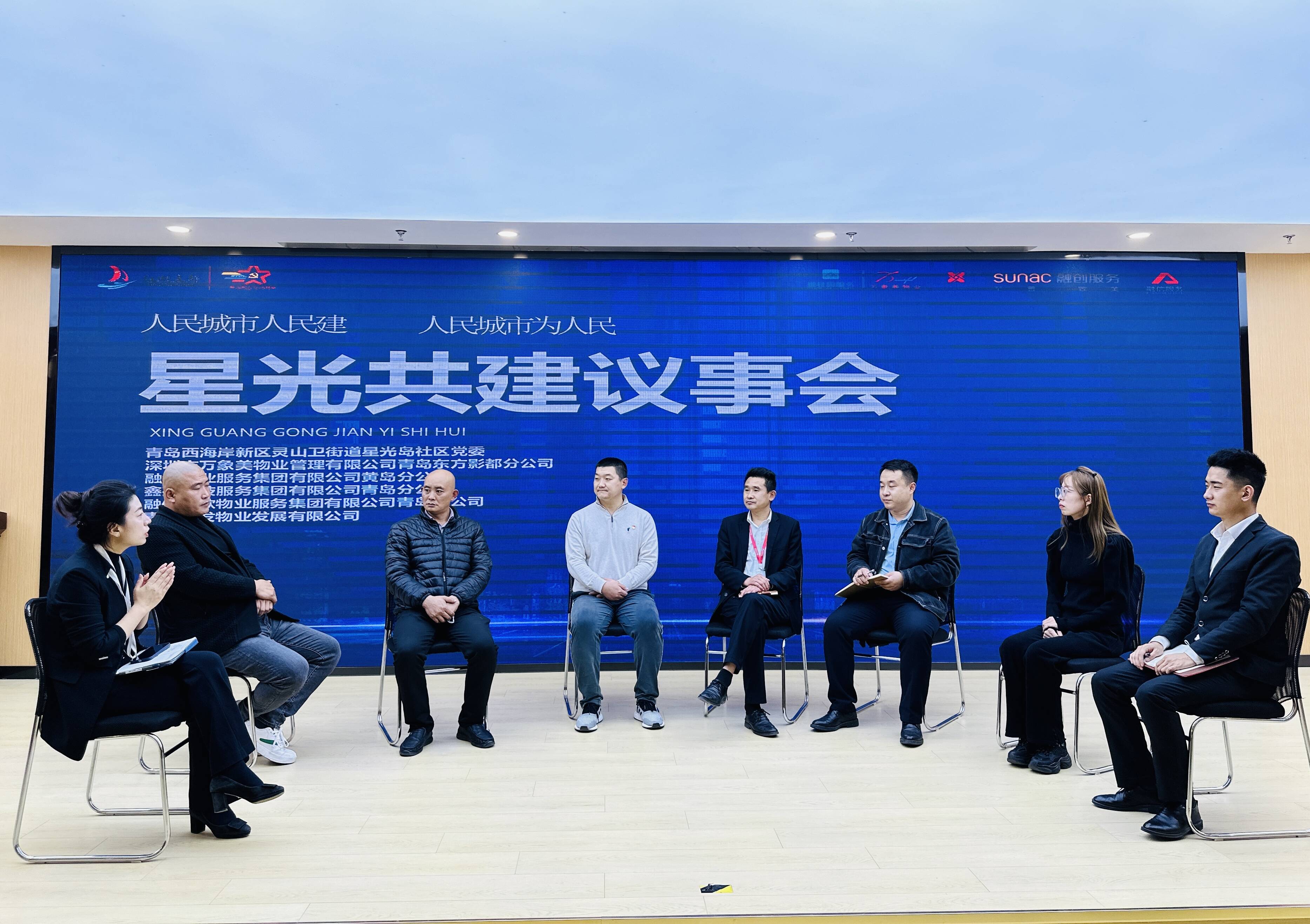 薛新伟（左一）和物业代表、居民代表围坐一起，共商社区治理难题。