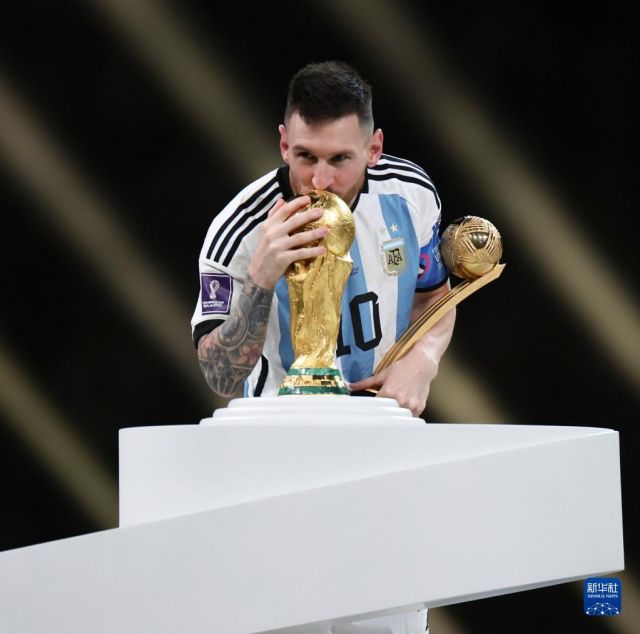 12月18日，获得世界杯金球奖的阿根廷队球员梅西在颁奖仪式上亲吻大力神杯。新华社记者 曹灿 摄