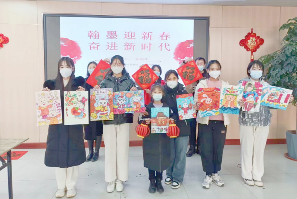 社区居民展示绘画作品和收到的福字。