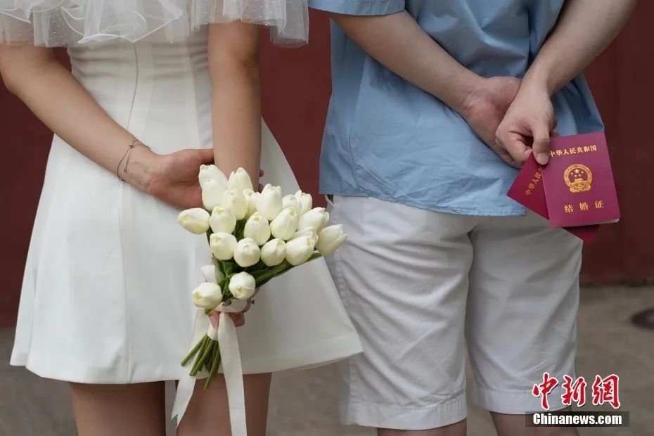 资料图：一对新人在登记结婚后合影留念。中新社记者 崔楠 摄