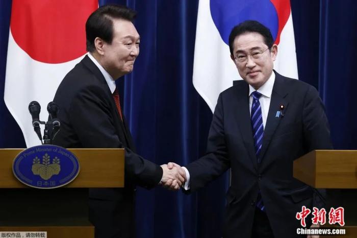 3月16日，韩国总统尹锡悦(左)与日本首相岸田文雄(右)在东京举行联合新闻发布会后握手。