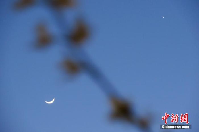 资料图：北京，天气晴好，太阳落山之后，天宇“金星合月”天文景观清晰可见。中新社记者 孙自法 摄