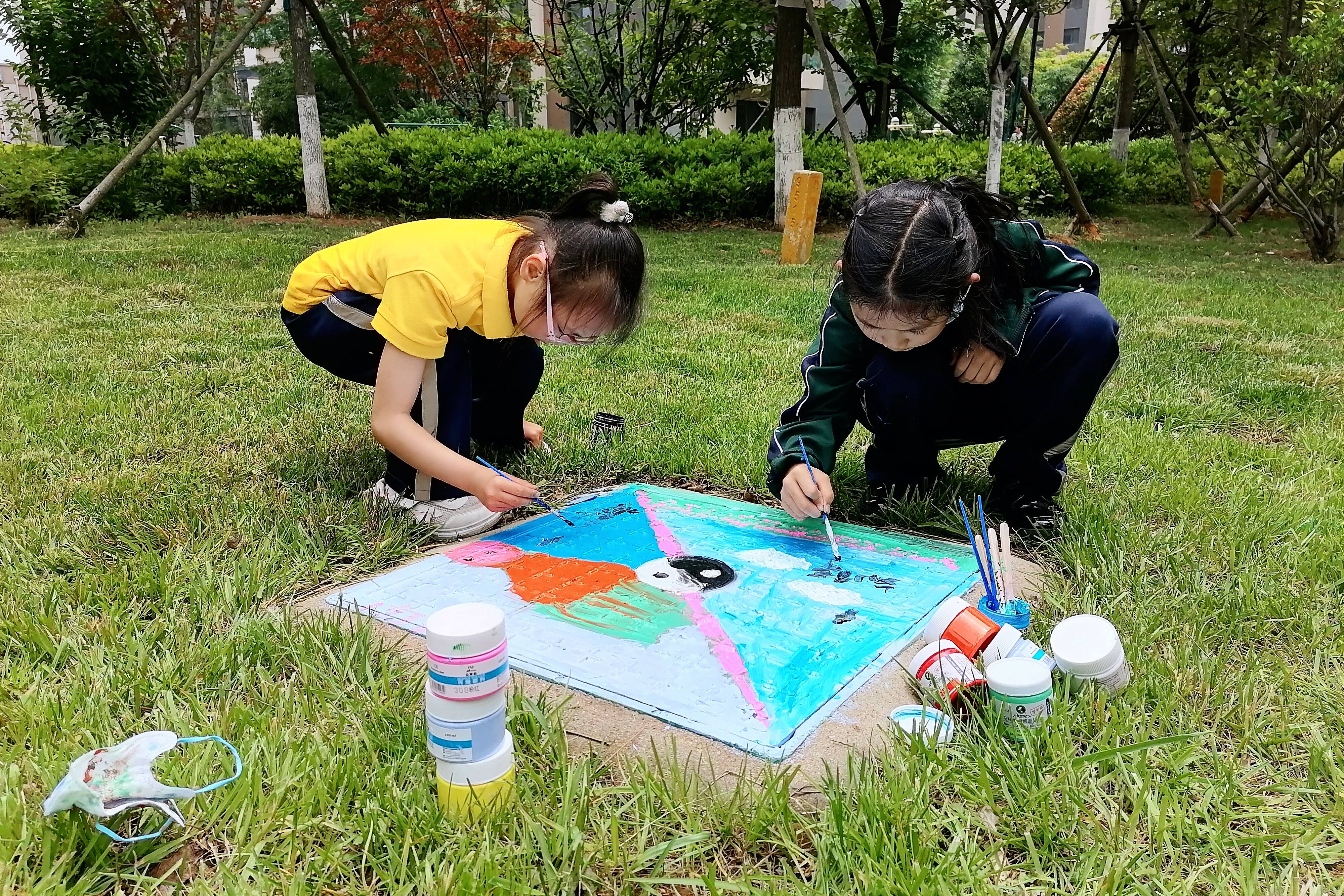 星光岛玫瑰园小区居民参与井盖涂鸦，扮靓小区环境。