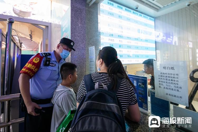 图：铁路公安在济南火车站售票大厅协助旅客办理儿童临时身份证明。（海报新闻记者 毕胜 摄）