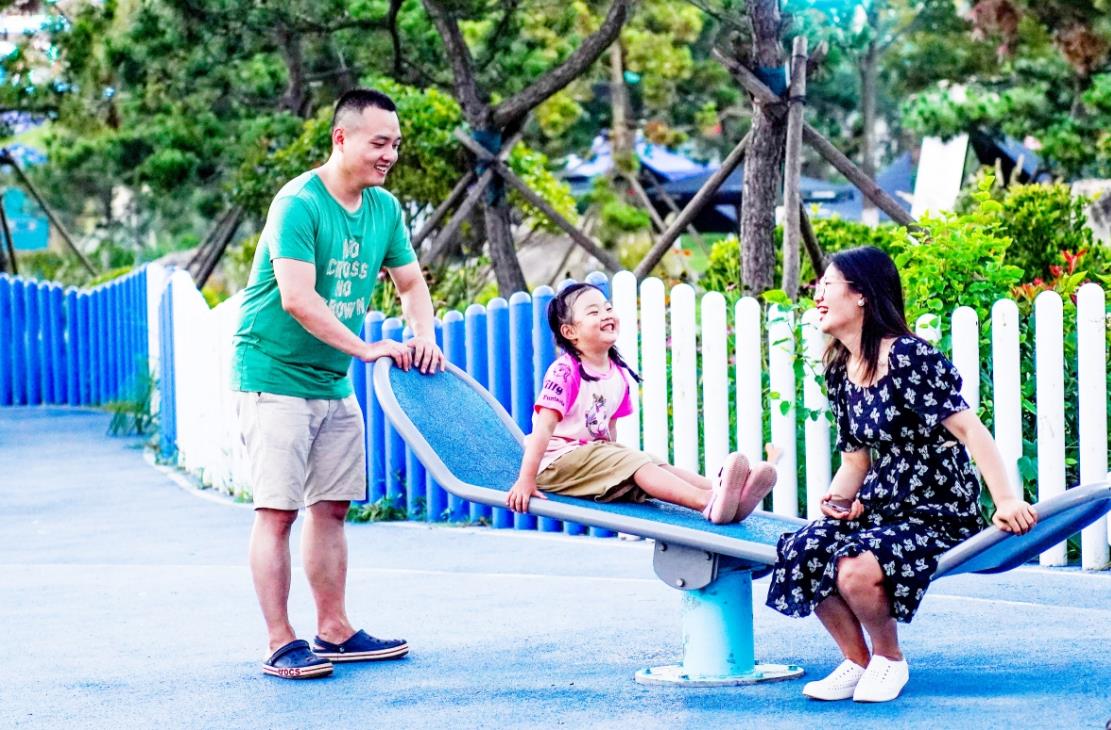 在跷跷板上乐享美好亲子时光的幸福一家人。