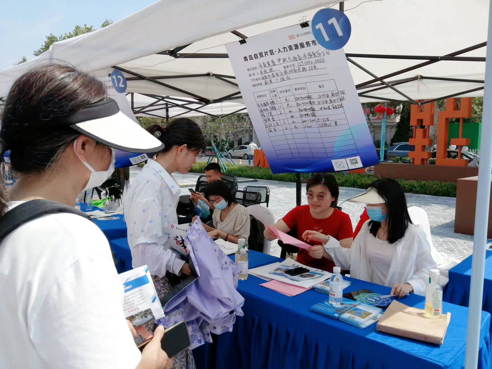 招聘会现场，工作人员为求职者介绍岗位信息。