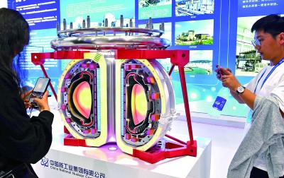 日前，在2023绿色低碳高质量发展大会装备展上，参观者在观看中国环流三号可控核聚变实验装置模型。新华社记者徐速绘摄