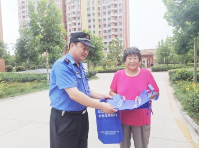 执法队员向居民宣传“六无”小区创建活动。记者 李涛报道