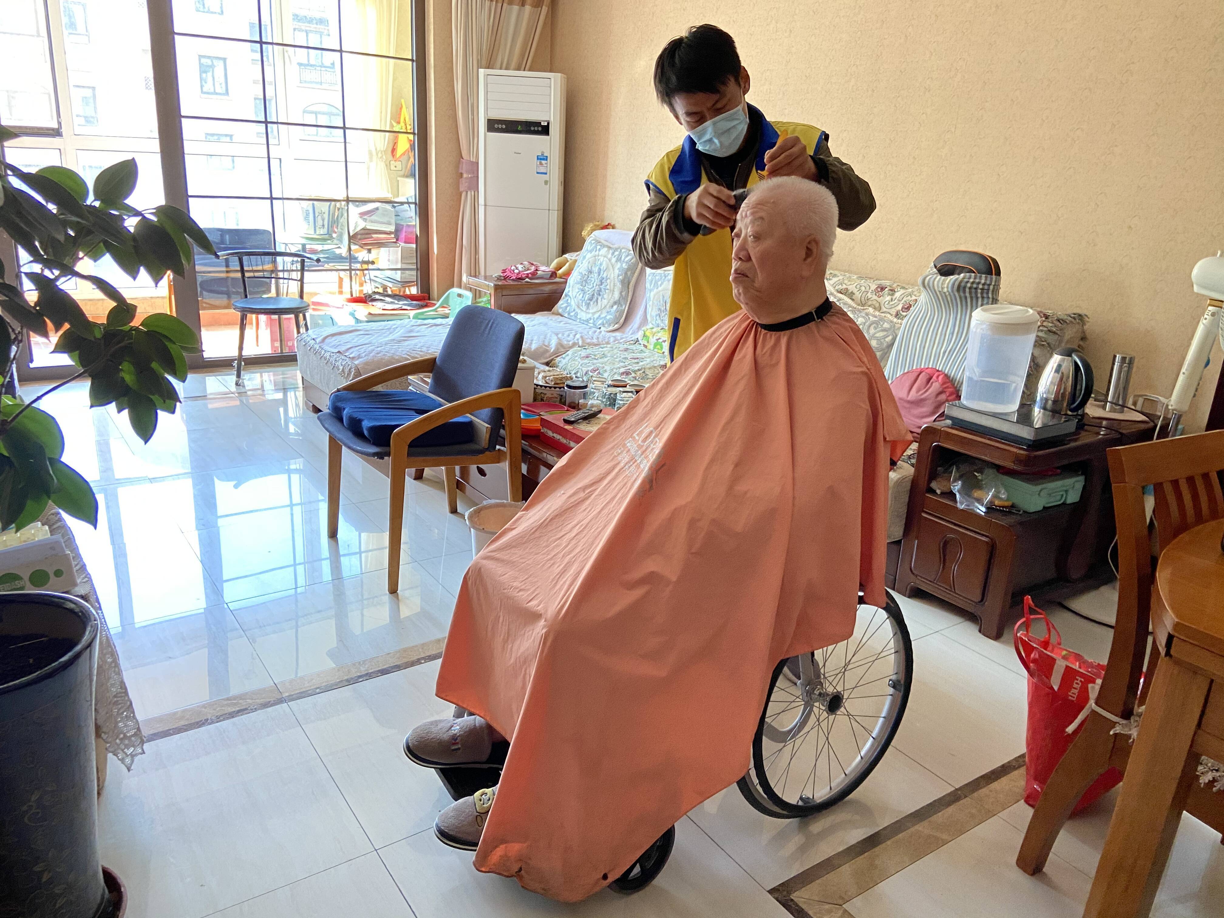 社区志愿者上门为老人理发。记者 丁霞 报道