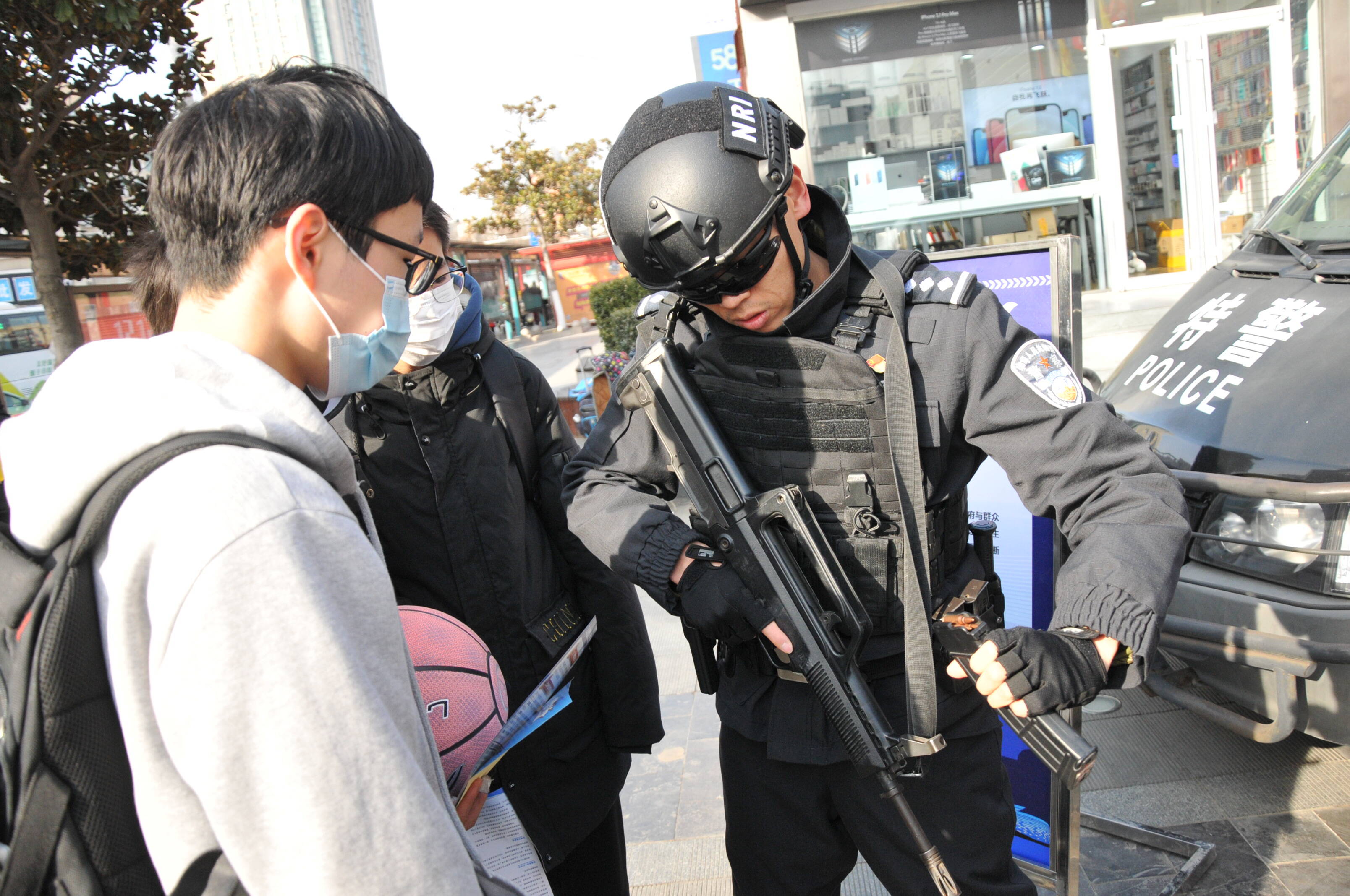 香江路利群购物广场门口，青岛开发区公安分局民警向市民展示装备。