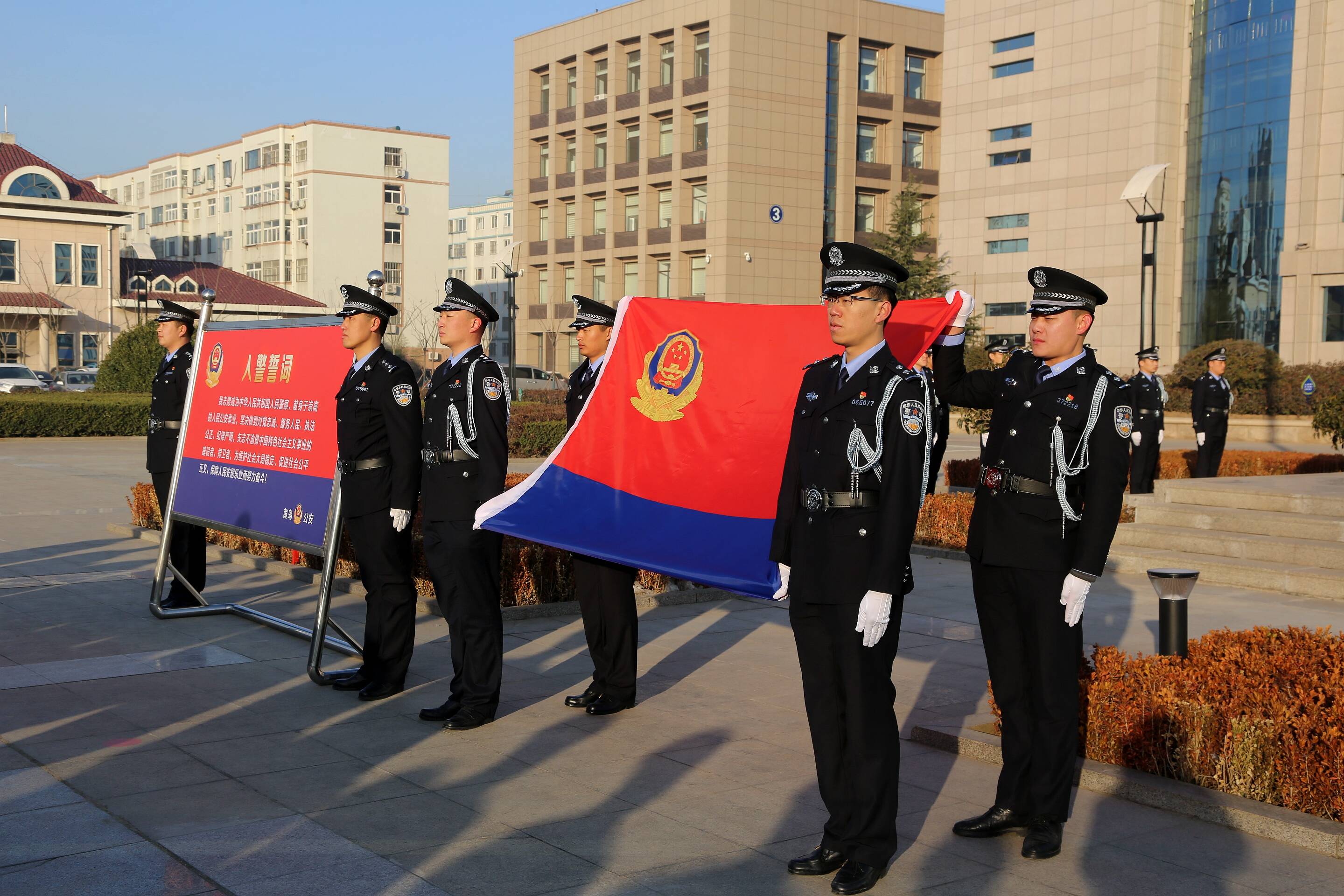 首个中国人民警察节当日，黄岛公安分局民警举警旗宣誓。