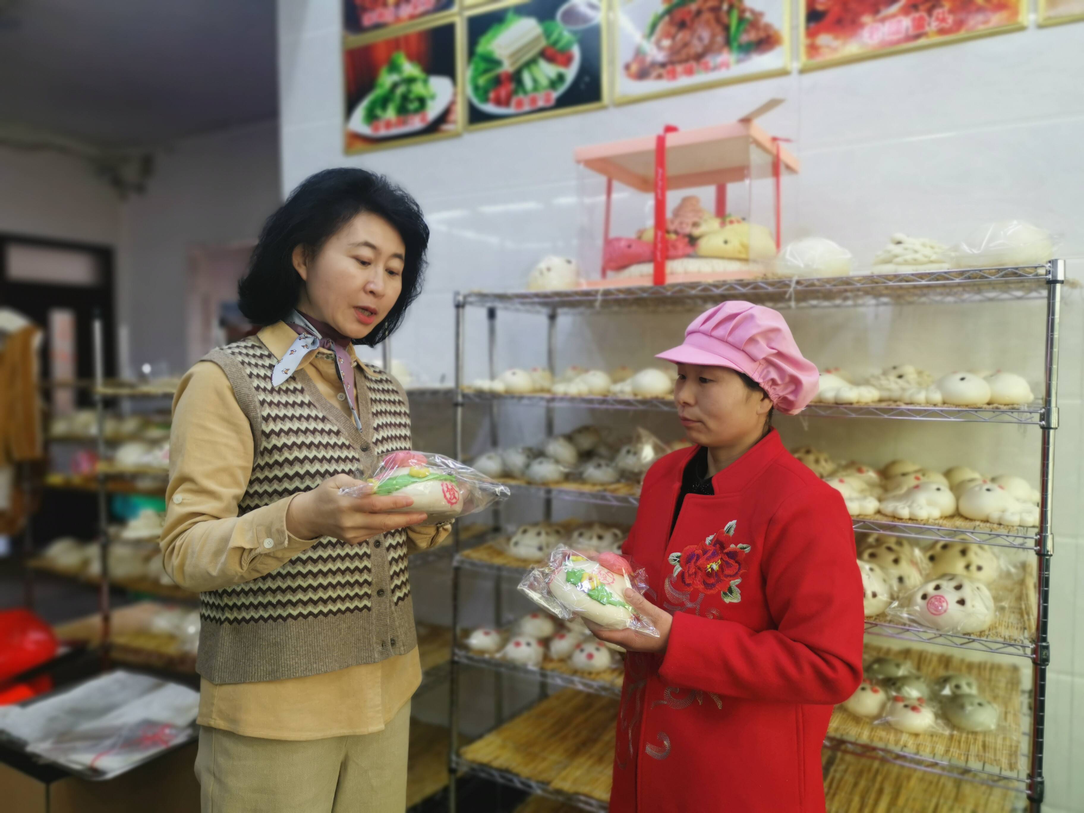 杨晓莉（左）和王娟在一起探讨花馍产销问题。记者 梁玉鹏 报道