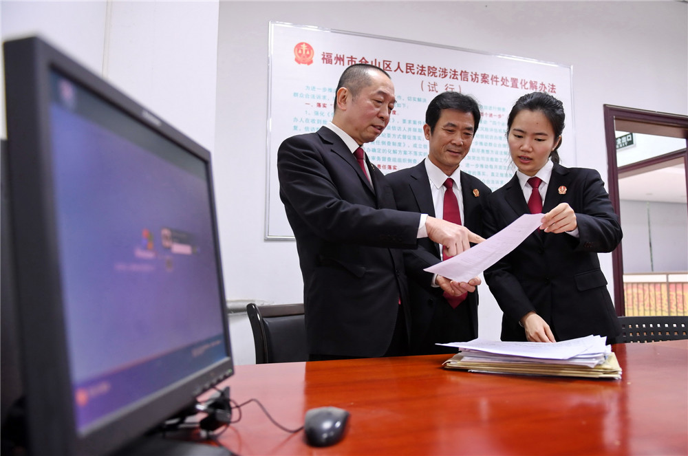 福建省福州市仓山区人民法院工作人员李扬（右）和同事在研究处理12368诉讼服务热线的群众意见（2019年1月17日摄）。服务热线主要负责法律咨询、案件查询、联系法官、收集意见建议等，为人民群众提供精准、便捷的服务。新华社记者 林善传 摄