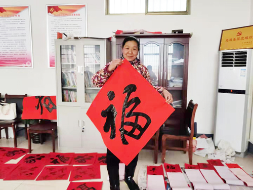 村民们手捧各自喜欢的春联,脸上洋溢着喜悦的笑容。 村民们手捧各自喜欢的春联,脸上洋溢着喜悦的笑容。