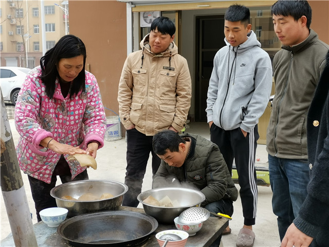 冯再峰一家人在院子里煮猪肉，过好日子