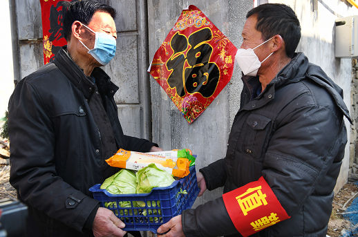 2月3日，冯卯镇下粉村村干部（右）上门为在家隔离观察的武汉返乡人员送去蔬菜、面条等生活用品。