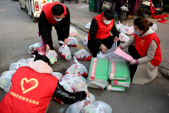 2月4日，在枣庄市市中区光明路街道陈庄社区，青年志愿者在为被居家隔离观察的居民清点购买的生活物品。