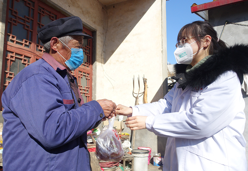 2月19日，桑村镇中心卫生院的医生将中药防疫汤剂送到当地贫困户手中。