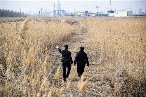 民警在油田作业井组附近巡逻，排查安全隐患。