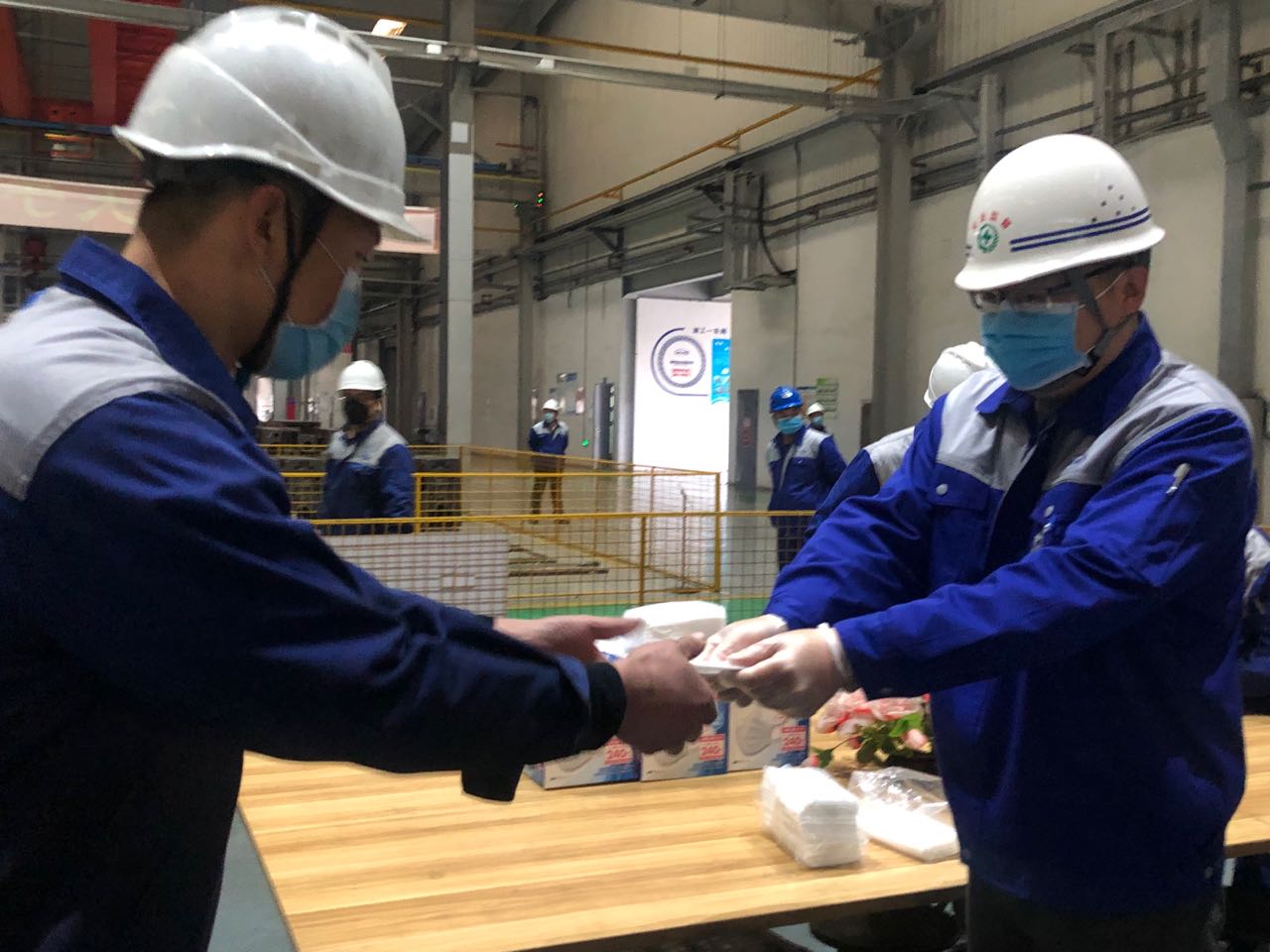2月25日，淄柴工业园车间内，工人正在领公司配发的口罩。