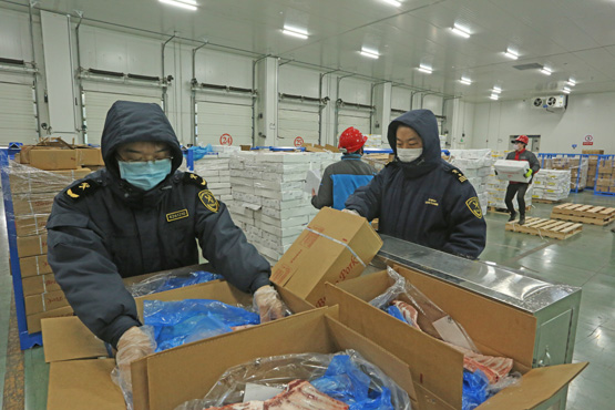 海关关员对进口肉类现场检验检疫 （李娜 摄）