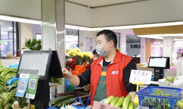 摊主正在操作智能秤，这项智能秤具有几十项能