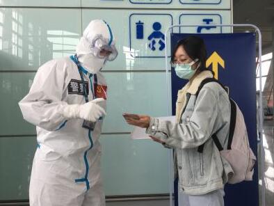  3月18日，首都机场公安局境外输入疫情防控突击队副队长路涛（左）在首都机场T3-D区帮助旅客解决问题。
