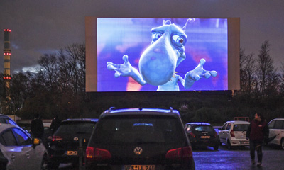  3月30日，在德国西部埃森，人们在汽车影院欣赏电影预告片。为遏制新冠肺炎疫情蔓延，德国的普通电影院纷纷关闭，许多人选择在汽车影院度过休闲时光。  (新华社/美联)