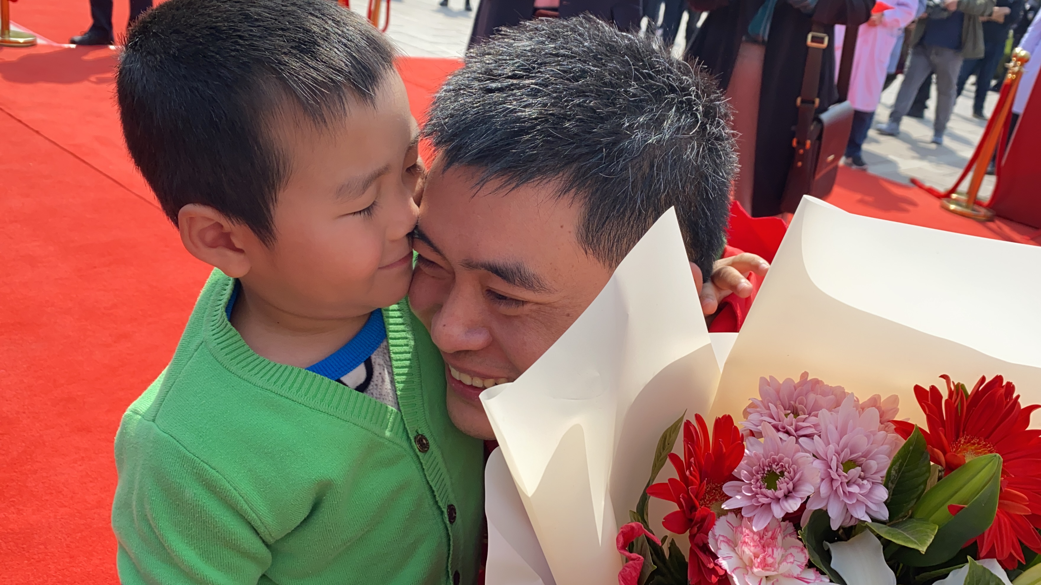 仪式结束后，淄博市妇幼保健院重症医学科护士长助力姬生伟和儿子拥抱在一起。