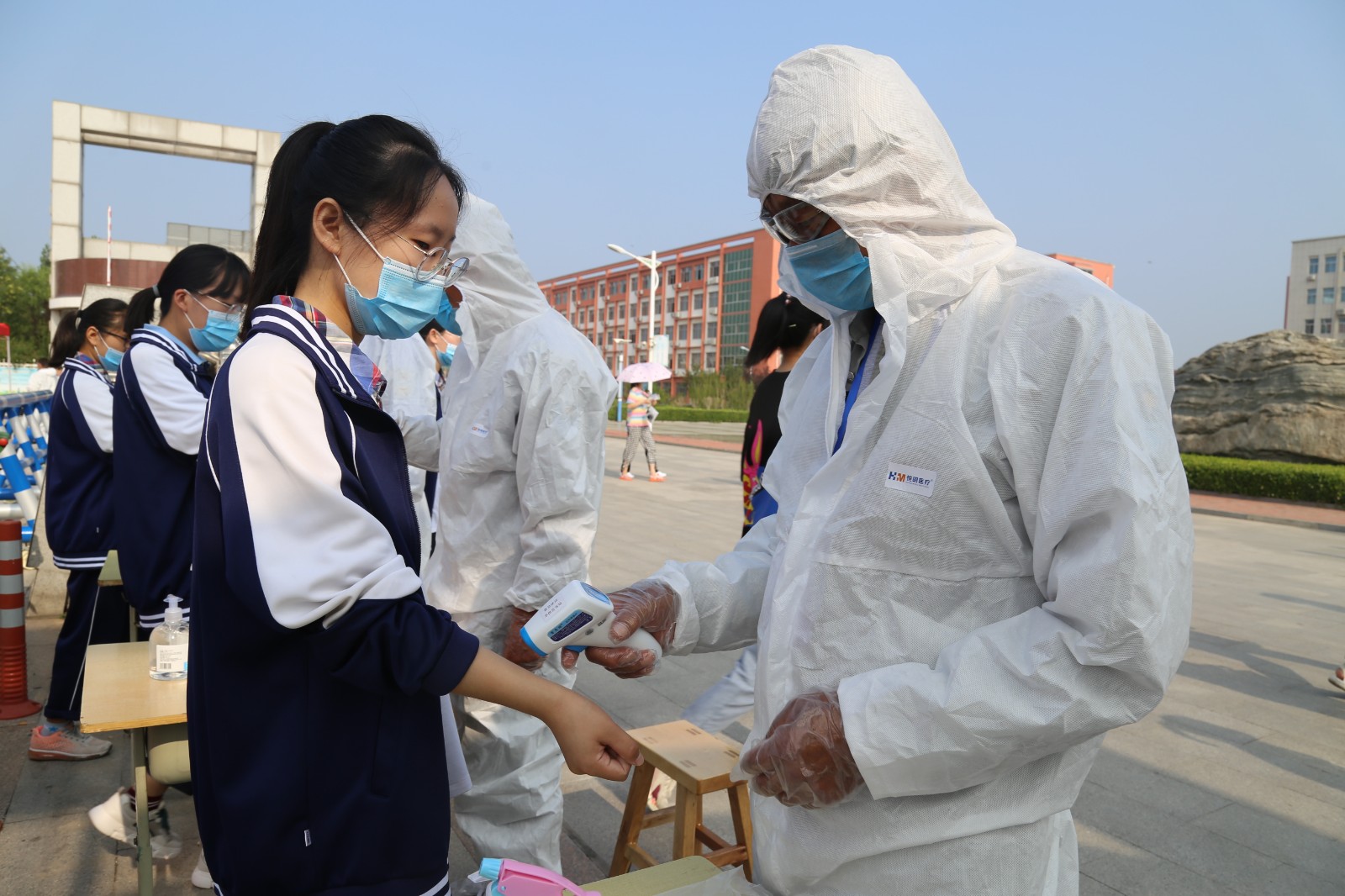 7月7日，在滨州市沾化区第一中学考点，工作人员对考生测量体温