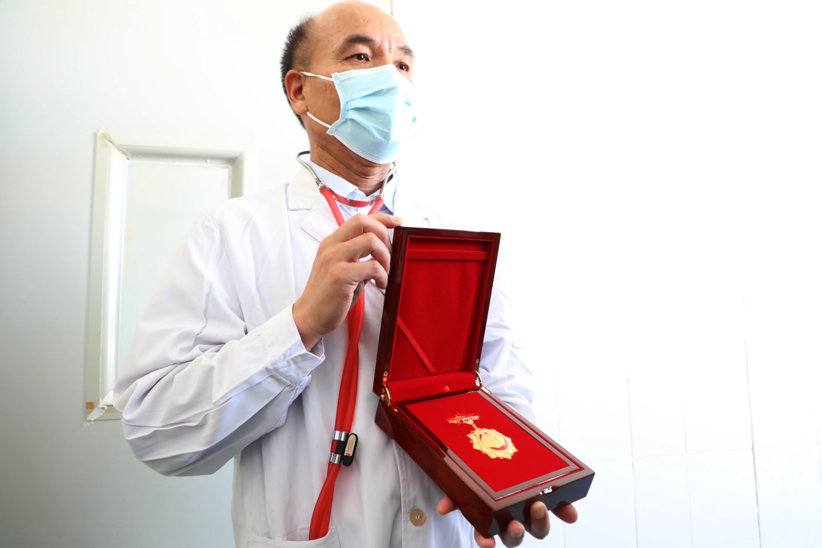 刘景春为记者展示其获得的奖章。