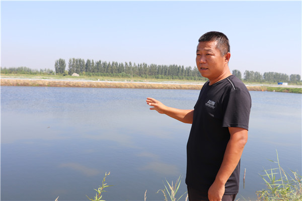 冯宪忠介绍自己养殖大闸蟹的情况。