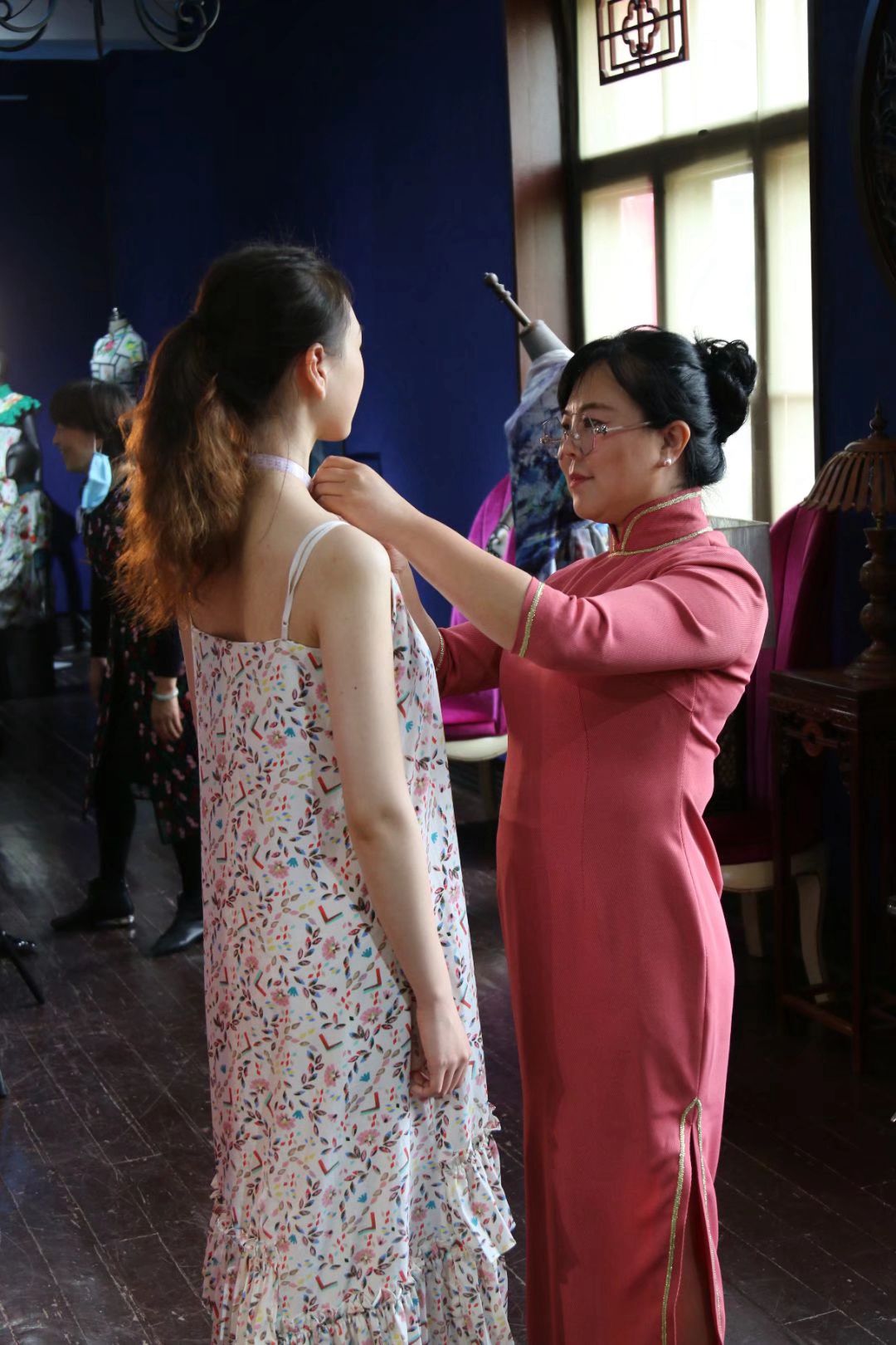 陈燕琴(右）在给旗袍爱好者设计旗袍尺寸。
