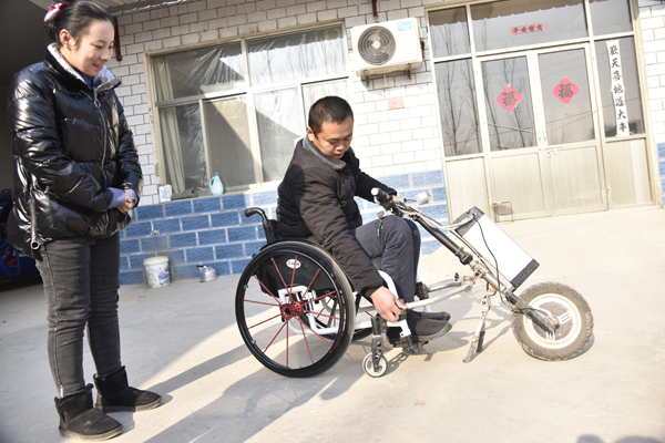 12月20日，郎廷秀给前来的镇、村干部讲述他的发明创作，自己动手制作安装了电动轮椅车头。