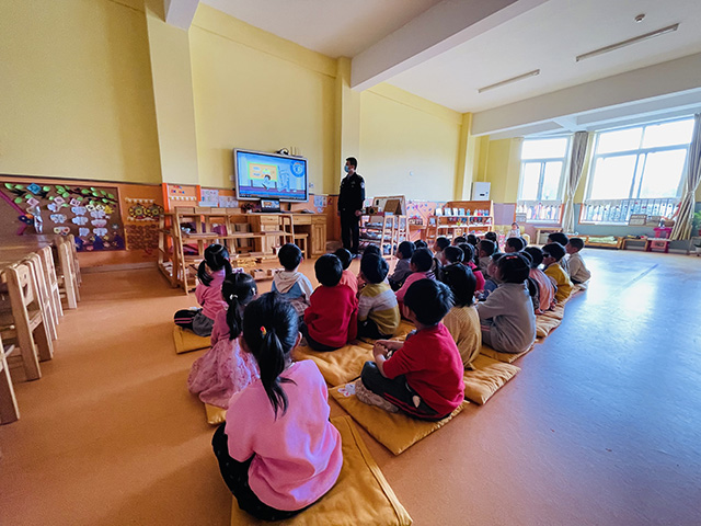 防灾减灾综合教育课堂上，民警和小朋友们一起观看宣传动画。