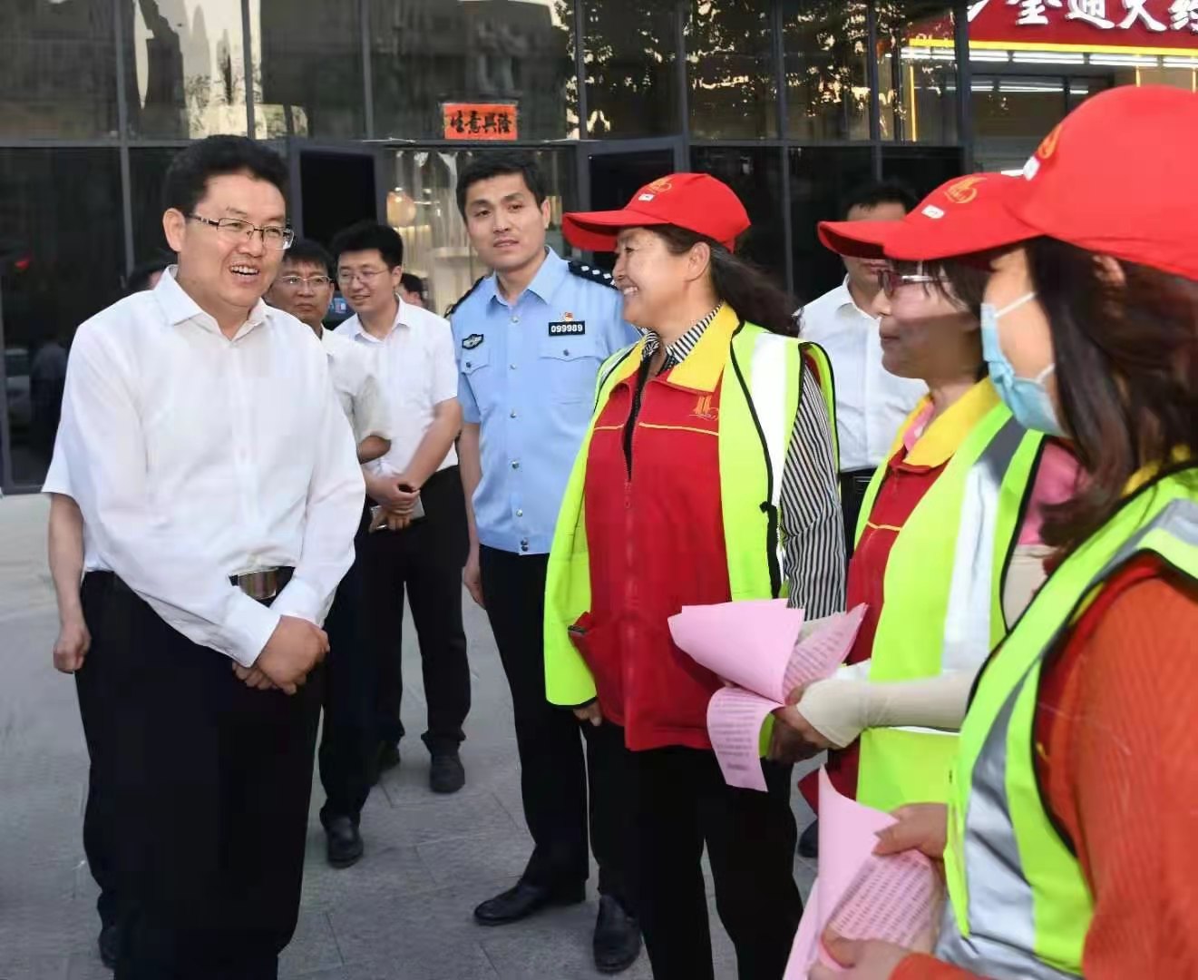 潍坊市委书记田庆盈在调研公共场所限时免费停车工作时，与参与停车服务的志愿者交流。