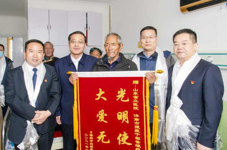 重见光明后，74岁的藏族同胞普布索朗赠送锦旗表示感谢