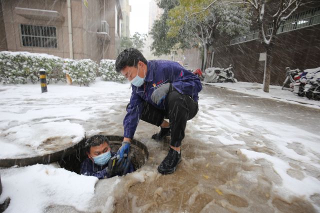 工作人员冒雪检修管道