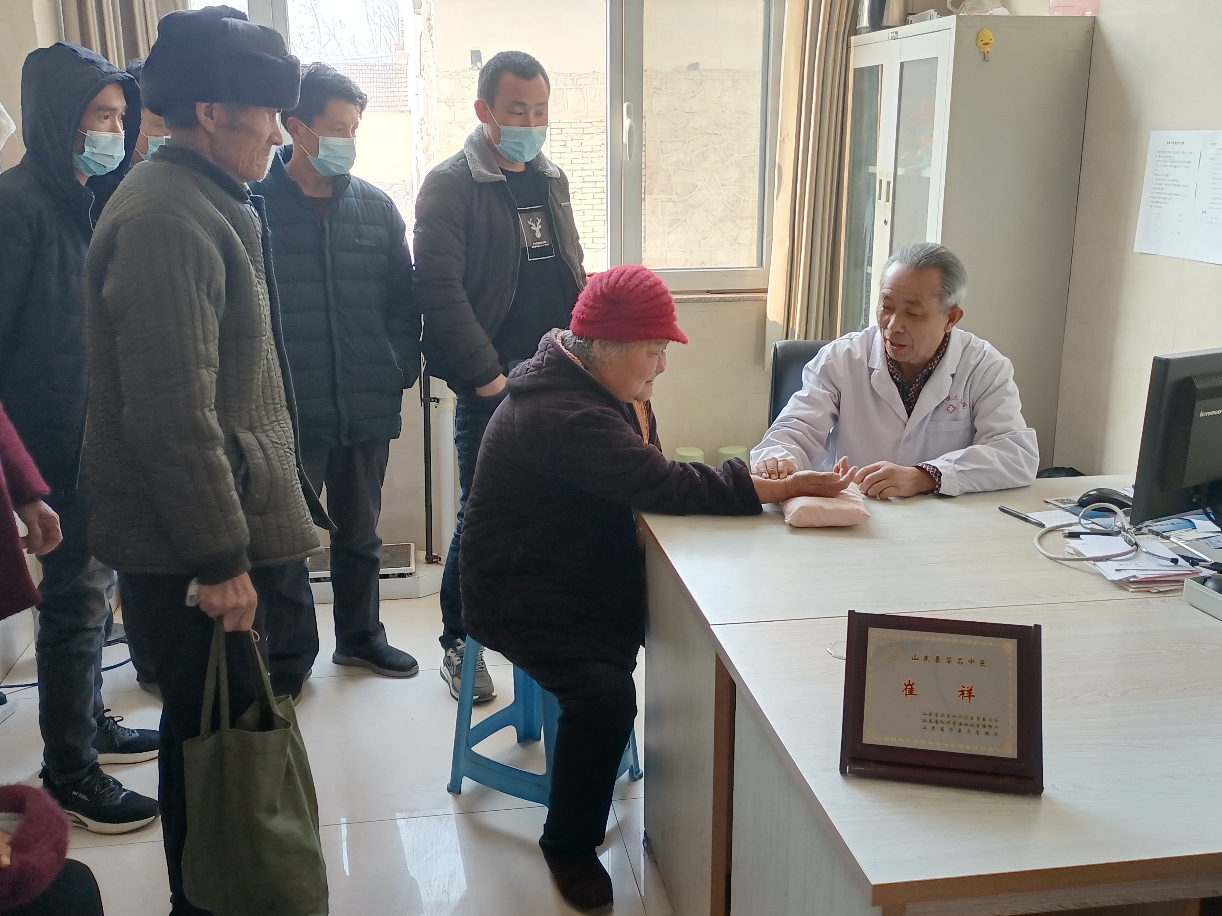 崔金峰的父亲崔祥正在给病人把脉